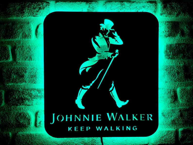 May include: A black and green neon sign with the Johnnie Walker logo. The logo features a man in a top hat walking with a cane. The text "Keep Walking" is below the logo.