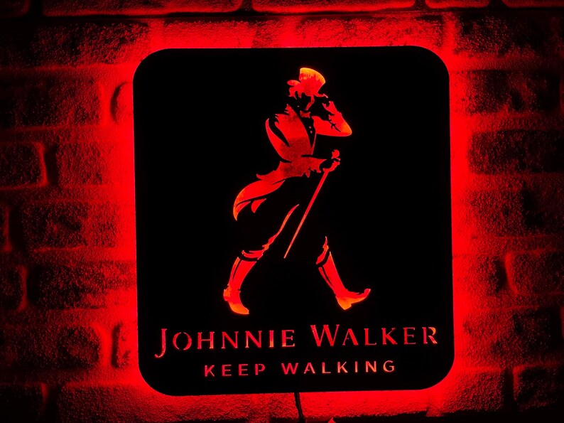 May include: A red neon sign with a black background featuring a silhouette of a man in a top hat and the text "JOHNNIE WALKER KEEP WALKING".