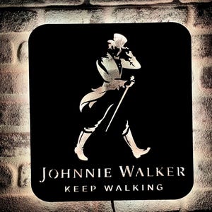 May include: Black and white silhouette of a man in a top hat and walking stick, with the text "JOHNNIE WALKER KEEP WALKING" on a black background.