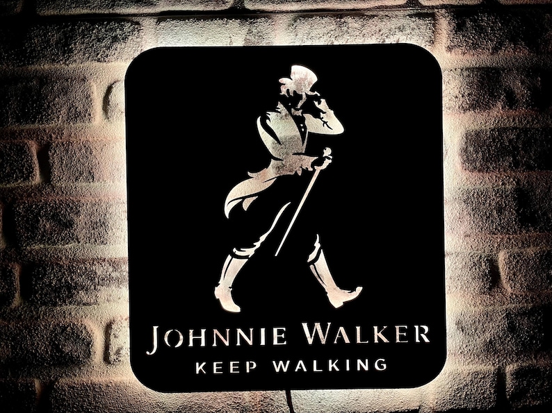 May include: Black and white silhouette of a man in a top hat and walking stick, with the text "JOHNNIE WALKER KEEP WALKING" on a black background.