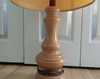 May include: A ceramic table lamp with a beige shade and a beige base. The base has a bulbous shape with a brown cord wrapped around it.