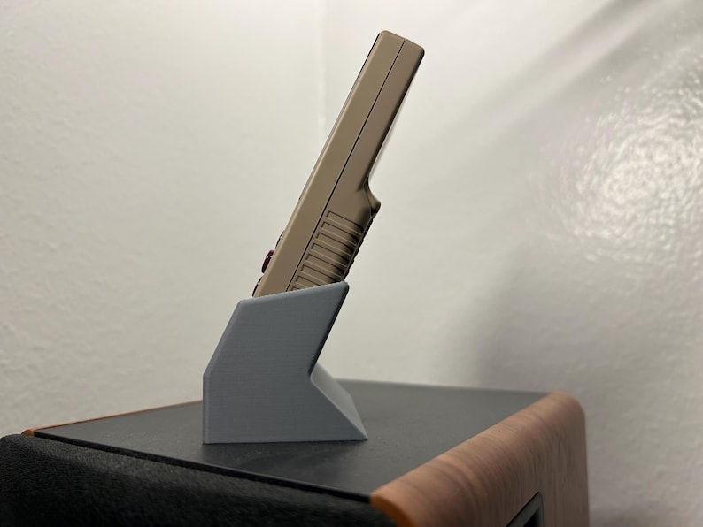 Miyoo Mini plus handheld gaming device shown in the gray dock, showing the aesthetic angle from the side.