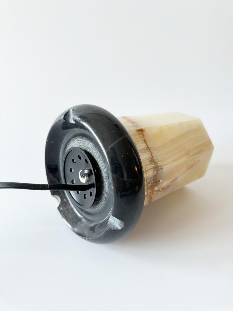 May include: A black and white onyx lamp with a black cord. The lamp has a round base and a hexagonal body.