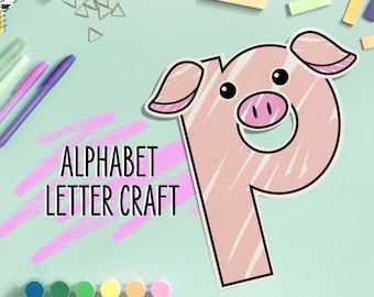 Puede incluir: Una letra P rosa con forma de cerdo con un hocico rosa y ojos negros. La letra está sobre un fondo azul claro con el texto "Alphabet Letter Craft" en negro.