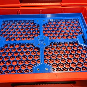 Puede incluir: Una bandeja organizadora de pl&aacute;stico azul con un patr&oacute;n de panal. La bandeja est&aacute; dise&ntilde;ada para encajar en un contenedor de almacenamiento m&aacute;s grande. La bandeja tiene cuatro secciones y est&aacute; asegurada con tornillos.