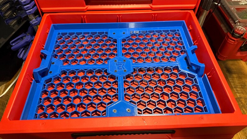 Puede incluir: Una bandeja organizadora de pl&aacute;stico azul con un patr&oacute;n de panal. La bandeja est&aacute; dise&ntilde;ada para encajar en un contenedor de almacenamiento m&aacute;s grande. La bandeja tiene cuatro secciones y est&aacute; asegurada con tornillos.