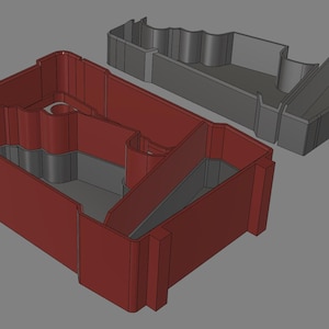 May include: A red plastic storage box with a grey interior. The box has a unique shape with multiple compartments and is designed to hold small items.