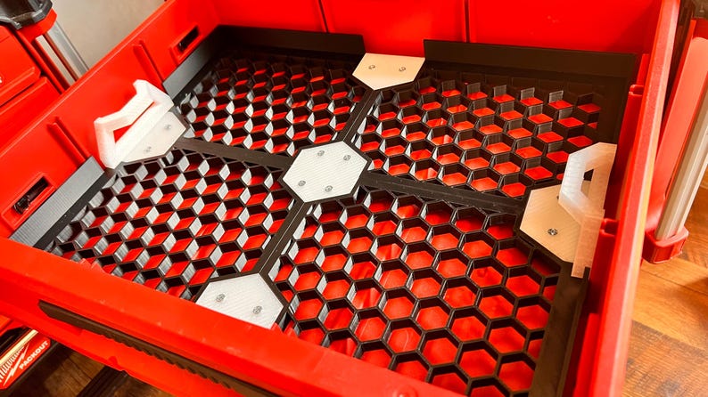 Puede incluir: Contenedor de almacenamiento de pl&aacute;stico rojo con un inserto de rejilla de panal negro y divisores de pl&aacute;stico blanco. Los divisores tienen peque&ntilde;as asas de pl&aacute;stico blanco.