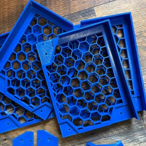 Puede incluir: Un conjunto de cinco paneles de pl&aacute;stico azul con patr&oacute;n de panal. Los paneles est&aacute;n apilados uno encima del otro y parecen ser parte de una estructura m&aacute;s grande.