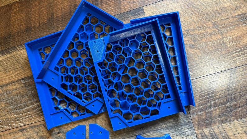 Puede incluir: Un conjunto de cinco paneles de pl&aacute;stico azul con patr&oacute;n de panal. Los paneles est&aacute;n apilados uno encima del otro y parecen ser parte de una estructura m&aacute;s grande.