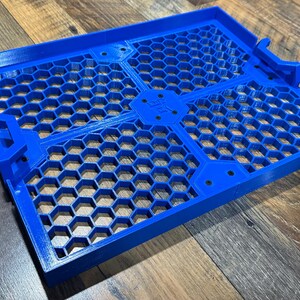 Puede incluir: Una bandeja de pl&aacute;stico azul con un patr&oacute;n de panal. La bandeja est&aacute; dividida en cuatro secciones y tiene un borde elevado.