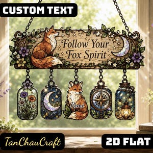 May include: A hanging wooden sign featuring a fox illustration and the text Follow Your Fox Spirit, with five dangling ornaments including flowers, a crescent moon, a fox with the name Remi, a compass, and a lantern, all in a stained glass style.