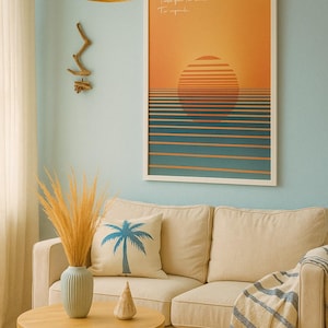Pode incluir: Cena de sala de estar com parede azul clara, sofá bege e mesa de centro redonda de madeira. Uma impressão artística emoldurada retrata um pôr do sol sobre o oceano. Uma almofada com palmeira e um vaso com plantas secas.