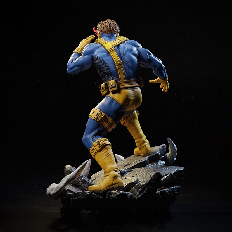 May include: A detailed figurine of the X-Men character Cyclops, in a dynamic pose. The figure is clad in a blue and yellow costume, with a red visor. The statue is standing on a rocky base, with a black background.