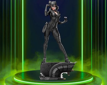 May include: A black Catwoman statue with a whip, standing on a stone base. The figure is wearing a black catsuit, cat-ear headpiece, and glasses. The background features green neon lights and the word "Rilabe".