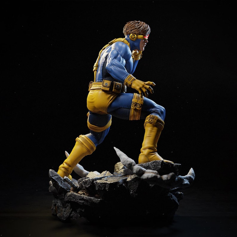 May include: A detailed figurine of a superhero in a dynamic pose. The figure is clad in a blue and yellow costume, with a red visor. The figure is standing on a rocky base, with a dark background.