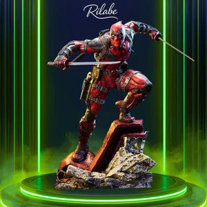 May include: A detailed statue of Deadpool in a dynamic pose, clad in a red and black suit, holding two katanas. The figure stands on a rocky base with a skull, set against a neon green and dark background. The Rilabe logo is at the top.
