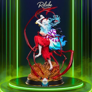 May include: A detailed figurine of a character with white skin, red clothing, and multi-colored hair. The figure is posed dynamically, holding a red weapon. The base is brown and gold, with a skull emblem. The word "Rilabe" is written at the top.