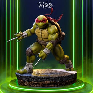 Puede incluir: Una figura detallada de Rafael de las Tortugas Ninja. La figura es verde con una máscara roja, sosteniendo dos sai. La base es un diseño de alcantarilla, con la palabra "Rilabe" en la parte superior central.