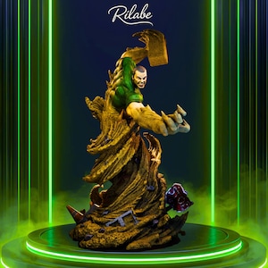 May include: A detailed statue of a comic book character, featuring a green and tan color scheme. The figure is posed dynamically, with a muscular build and a determined expression. The base is a textured, earthy tone, and the background has green neon accents.