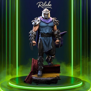 May include: A detailed statue of Shredder from Teenage Mutant Ninja Turtles. The figure is in a dynamic pose, wearing his signature armor, helmet, and cape. The statue is on a platform with a green and yellow background. The word "Rilabe" is written in white script at the top.