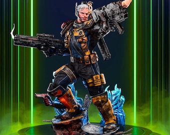 May include: A detailed statue of a character in a blue and yellow tactical suit, holding two large guns. The figure has a cybernetic arm and white hair. The statue is on a platform with blue and green accents, with the word "Rilabe" in the top center.