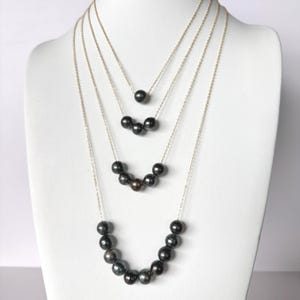 May include: A set of three ceramic mugs with a speckled, matte finish. The mugs are in shades of cream, light gray, and dark gray. Each mug has a simple, minimalist design, perfect for coffee or tea.