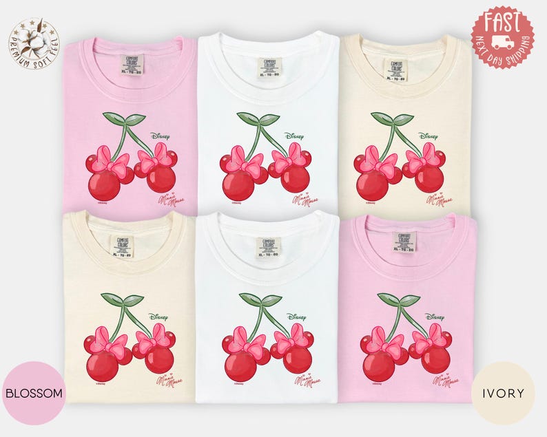 Peut inclure: Six t-shirts de couleurs vari&eacute;es : rose, blanc et ivoire. Chaque t-shirt pr&eacute;sente un motif de deux cerises rouges avec des n&oelig;uds roses et des tiges vertes, avec les logos Disney et Minnie Mouse.
