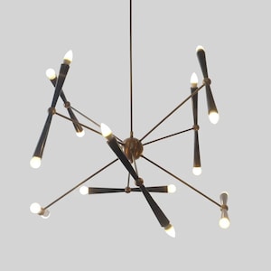 May include: A black and gold modern chandelier with multiple arms and light bulbs. The chandelier has a geometric design and is suspended from the ceiling.