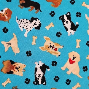May include: A turquoise fabric featuring a repeating pattern of various dog breeds in playful poses. The dogs are in shades of brown, black, white, and tan, with paw prints and bone shapes scattered throughout the design.