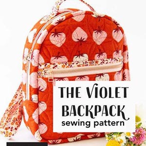 May include: A quilted orange backpack with a strawberry pattern and a floral zipper pocket. The text "THE VIOLET BACKPACK sewing pattern" is displayed on the front. The backpack has a handle and straps with a floral design. The logo "KNOT + THREAD design" is in the bottom left corner.
