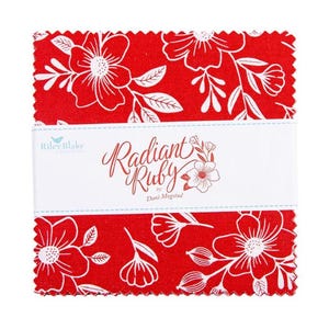 May include: A stack of red fabric squares with a white floral design. The fabric is wrapped with a white band that reads "Radiant Ruby" by Dani Mogstad. The Riley Blake Designs logo is also visible.