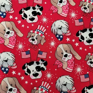 May include: Red fabric with a repeating pattern of cartoon dogs wearing red, white, and blue patriotic accessories. The dogs are wearing hats, bandanas, and bow ties with stars and stripes.