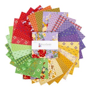 May include: A collection of colorful fabric squares arranged in a circular pattern. The squares feature various floral, geometric, and plaid designs in shades of red, green, yellow, and purple. The text "Vera's Garden" is visible on a white label.