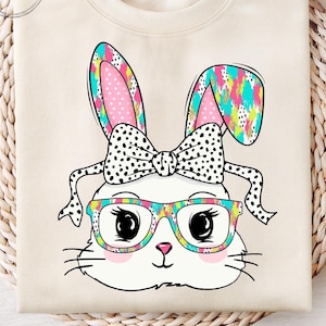 May include: A white bunny with pink ears and a black and white polka dot bow. The bunny is wearing colorful glasses and has a colorful abstract pattern on its ears.