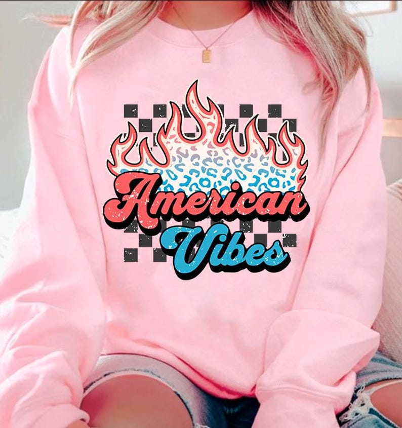 May include: Pink sweatshirt with a graphic of a flame with a leopard print design and the text "American Vibes" in a retro font.