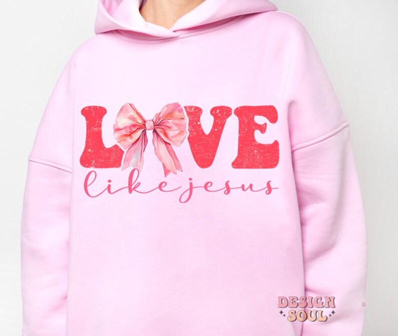 May include: Pink hoodie with the words "LOVE like JESUS" in red letters with a pink bow in the middle of the word LOVE.