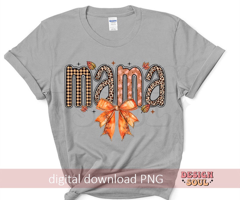 May include: Gray t-shirt with the word "mama" in a fall-themed design. The word is made up of different patterns, including plaid, leopard print, and floral. A large orange bow is below the word.