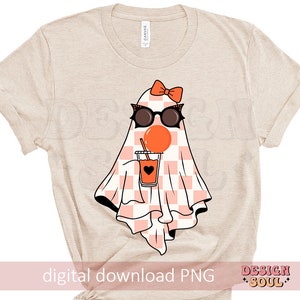 May include: A beige t-shirt with a graphic of a ghost wearing sunglasses and holding a cup of orange juice. The ghost has a pink bow on its head and a checkered pattern on its body. The text "digital download PNG" is at the bottom of the shirt.