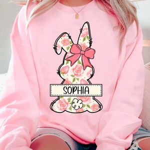 May include: Pink sweatshirt with a floral bunny design and the name "Sophia" in a banner.