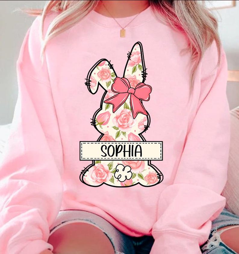 May include: Pink sweatshirt with a floral bunny design and the name "Sophia" in a banner.