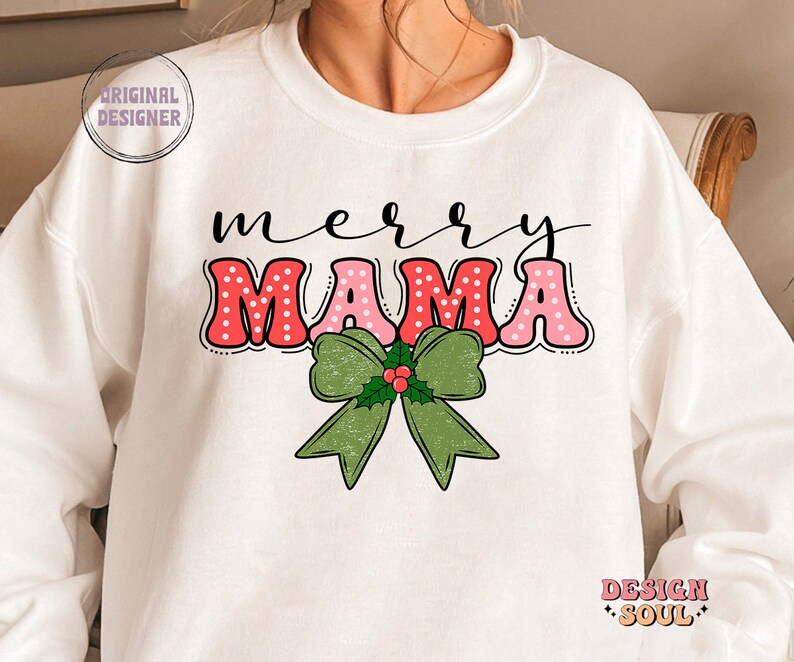 May include: White sweatshirt with a red and pink "merry mama" graphic with white polka dots. A green bow with holly and red berries is below the text.