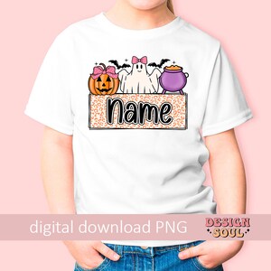 May include: A white t-shirt with a Halloween-themed design featuring a ghost, pumpkin, and cauldron. The design is on a leopard print background with the word "Name" in black text.