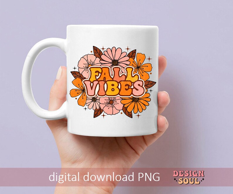 May include: White ceramic mug featuring a design of orange and pink flowers with the text "Fall Vibes" in a retro font.