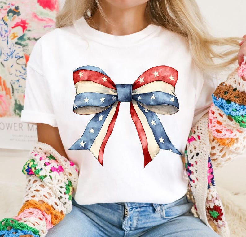 K&ouml;nnte beinhalten: Wei&szlig;es T-Shirt mit einer rot-wei&szlig;-blauen Schleife mit Sternen darauf.