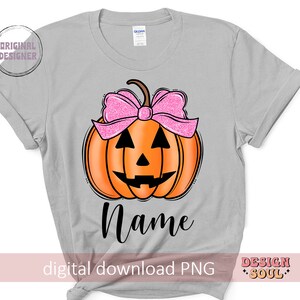May include: A gray t-shirt with a pumpkin design. The pumpkin has a pink bow and a jack-o'-lantern face. The text "Name" is below the pumpkin.  The shirt is a digital download PNG file.