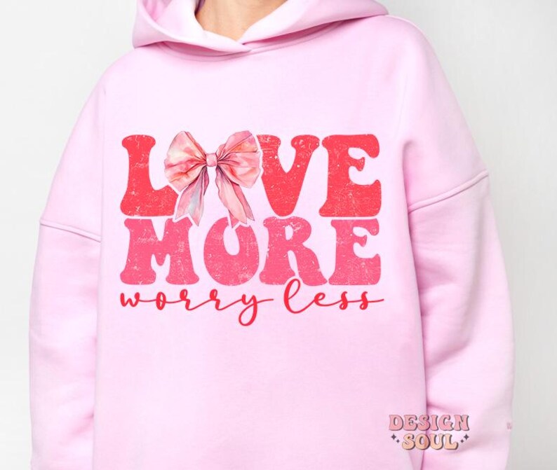 May include: Pink hoodie with a pink bow and the text "LOVE MORE worry less" in red and pink.