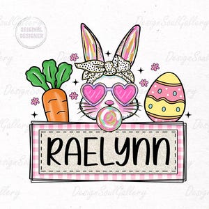 May include: A pink and white bunny with sunglasses and a lollipop is holding a sign with the name "RAELYNN" on it. The bunny is surrounded by pink and yellow Easter eggs and a carrot.