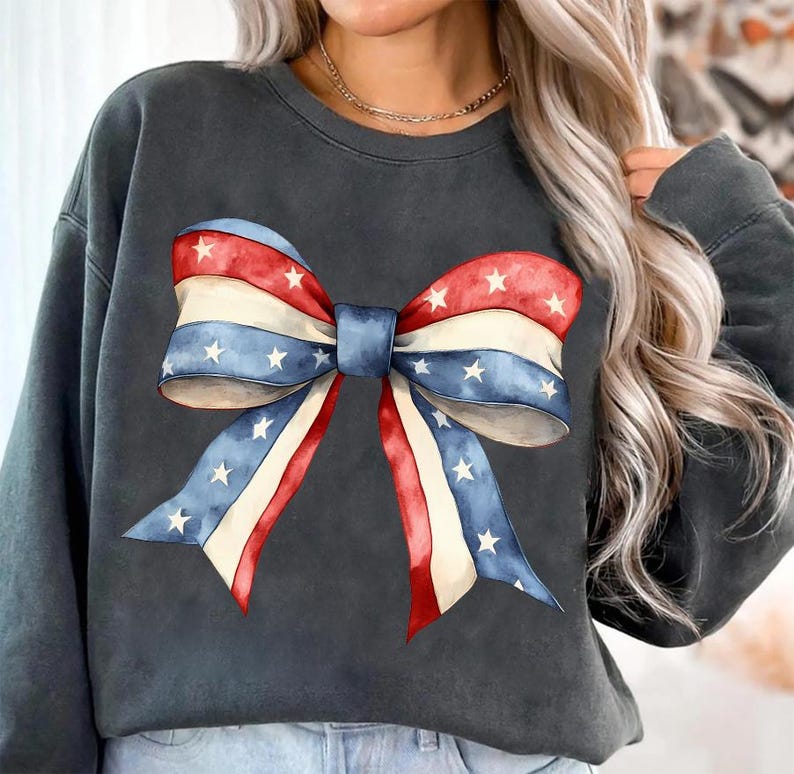 K&ouml;nnte beinhalten: Ein dunkelgraues Sweatshirt mit einer gro&szlig;en rot-wei&szlig;-blauen Schleife mit wei&szlig;en Sternen darauf.