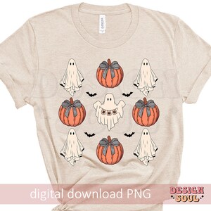 May include: Beige t-shirt featuring a Halloween design. The design includes orange pumpkins with gray bows, white ghosts, and black bats. One ghost has the word "BOO" on it. The words "digital download PNG" are at the bottom.